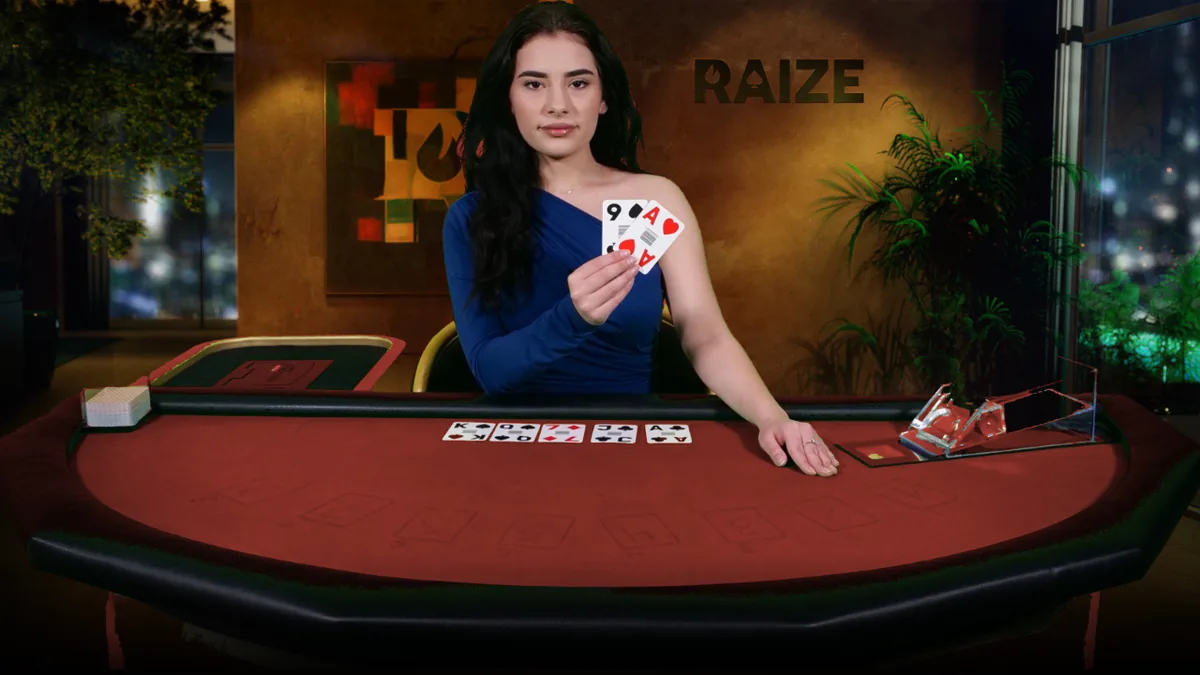 A RAIZE dealer holding two cards at a red-felt table, with a five-card community board dealt in front of her